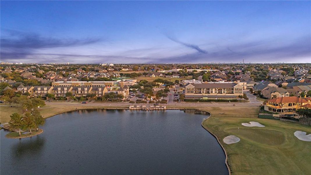 Aerial view of residential area with a nearby body of water and a golf club
