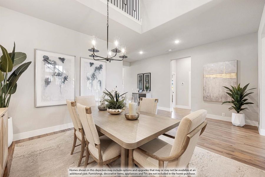 Dining room with wood table, six chairs, high ceiling, and chandelier over an area rug