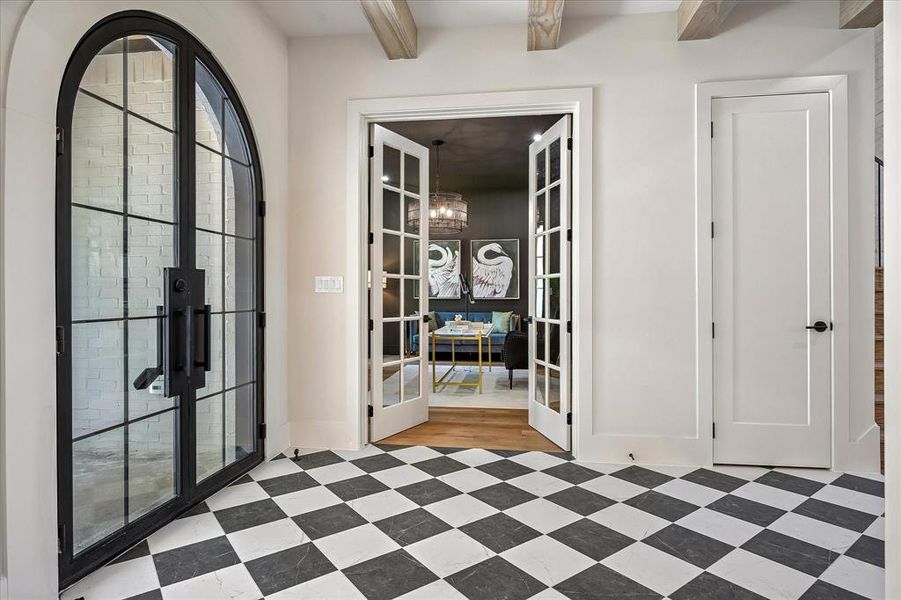 Arched iron and glass entry, checkered tile floor, French doors to study, exposed beam ceiling Arched iron and glass entry, checkered tile floor, French doors to study, exposed beam ceiling