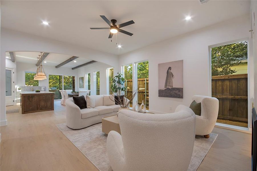 Living room with beam ceiling, light wood-style flooring, healthy amount of natural light, recessed lighting, and a ceiling fan