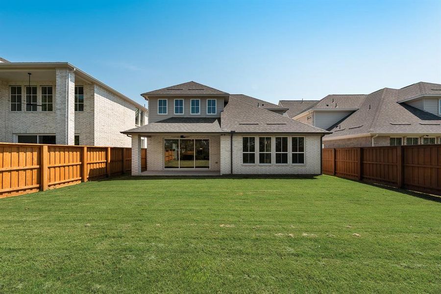 Rear view of house with brick siding, a fenced backyard, and a shingled roof Rear view of house with brick siding, a fenced backyard, and a shingled roof