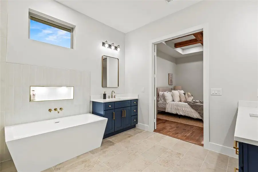 Full bathroom featuring vanity, a freestanding tub, and connected bathroom Full bathroom featuring vanity, a freestanding tub, and connected bathroom