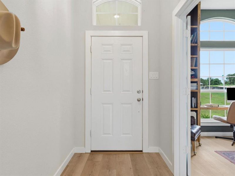 Bright and open entry with natural light, leading into spacious main living areas with farmhouse-style finishes.