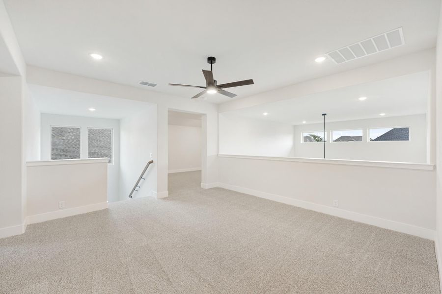 Spacious bonus room with carpet, ceiling fan, recessed lighting, and staircase opening near windows
