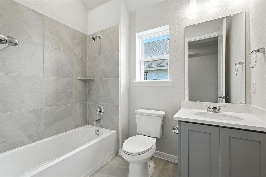 Bathroom featuring vanity, shower / tub combination, and a textured wall