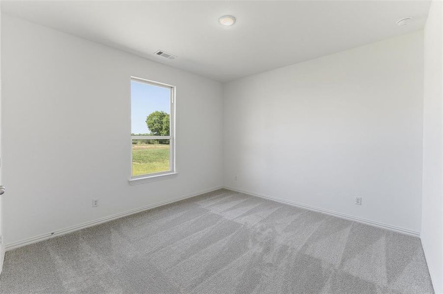 Neutral-toned room featuring a single window, recessed ceiling lighting, and light gray patterned carpeting