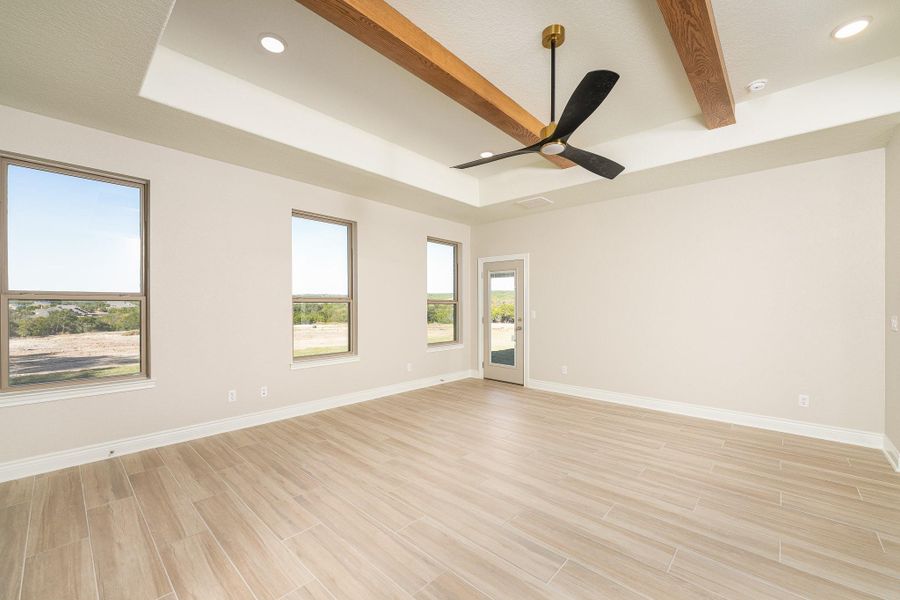 Unfurnished room featuring beamed ceiling, wood finish floors, recessed lighting, a ceiling fan, and a tray ceiling Unfurnished room featuring beamed ceiling, wood finish floors, recessed lighting, a ceiling fan, and a tray ceiling