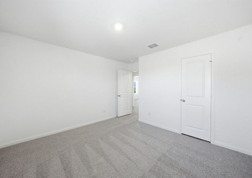 Carpeted Bedroom 2 featuring a closet doorway and neutral wall color. Carpeted Bedroom 2 featuring a closet doorway and neutral wall color.