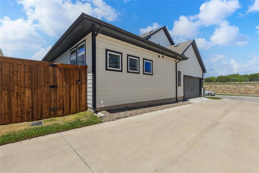 View of side of property featuring concrete driveway and an attached garage View of side of property featuring concrete driveway and an attached garage