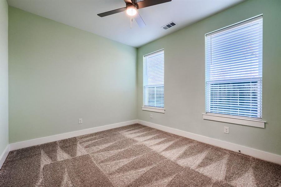 Spare room featuring carpet flooring and ceiling fan