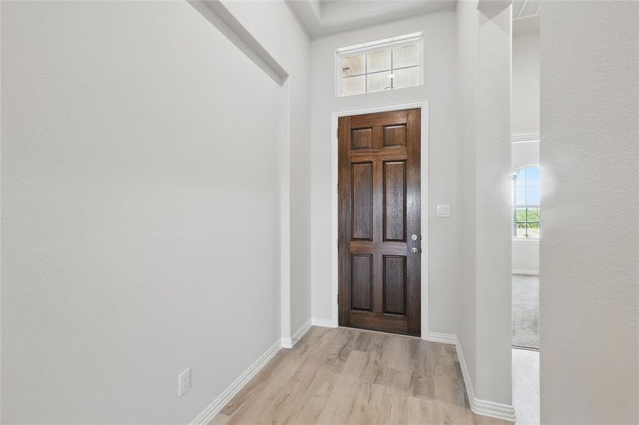 Entryway featuring light wood-type flooring and a high ceiling Entryway featuring light wood-type flooring and a high ceiling