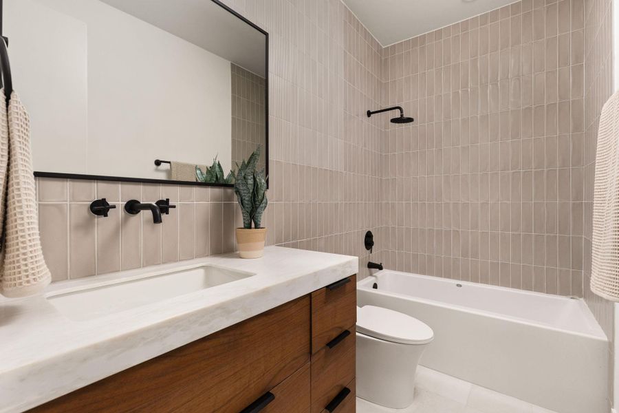 Modern bath with vertical tile surround and a sleek vanity.