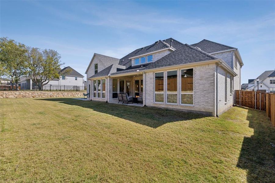 Rear view of house with a patio and a yard