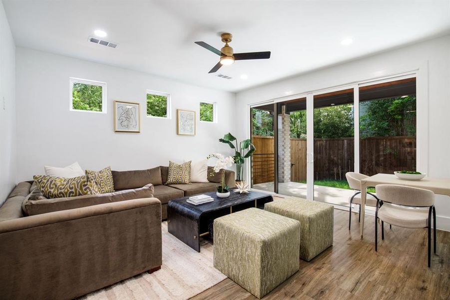 Open-concept living area featuring wood-finish flooring, recessed lighting, and a modern ceiling fan Open-concept living area featuring wood-finish flooring, recessed lighting, and a modern ceiling fan