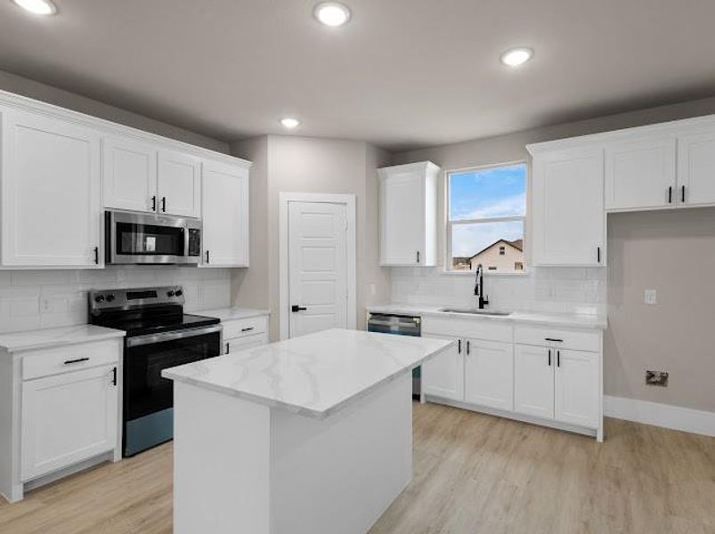 Kitchen featuring stainless steel appliances, decorative backsplash, light wood-style flooring, and recessed lighting