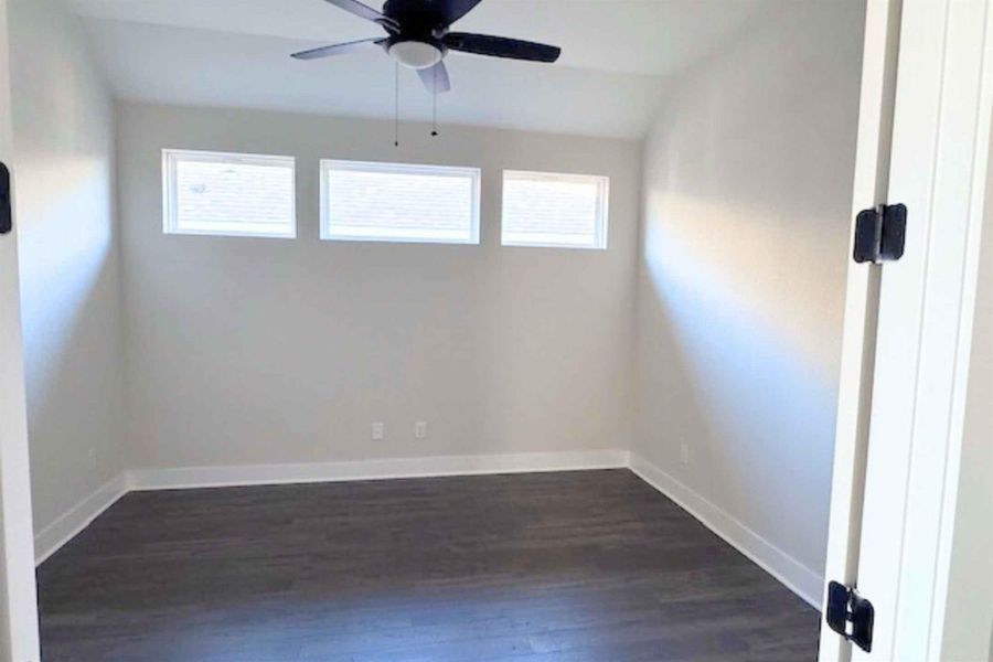 Unfurnished room with lofted ceiling, dark wood-type flooring, plenty of natural light, and ceiling fan