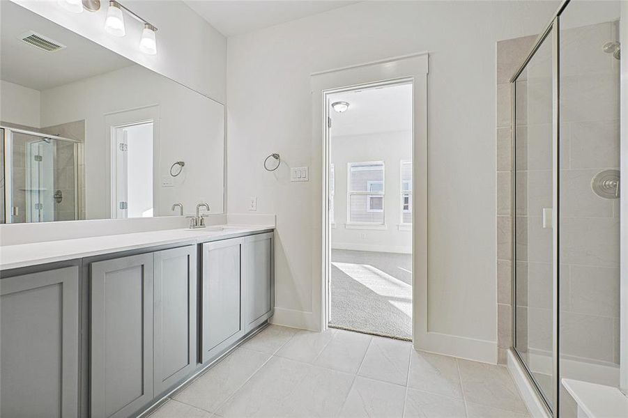 Bathroom with a stall shower, vanity, and tile patterned floors