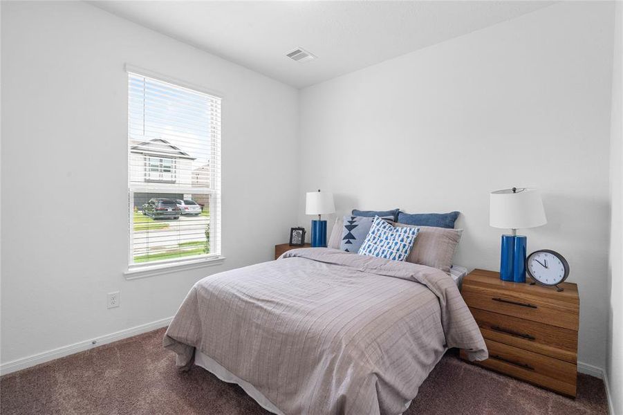 Secondary bedroom features plush carpet, neutral paint, lighting, large window with privacy blinds and ample sized closet space.