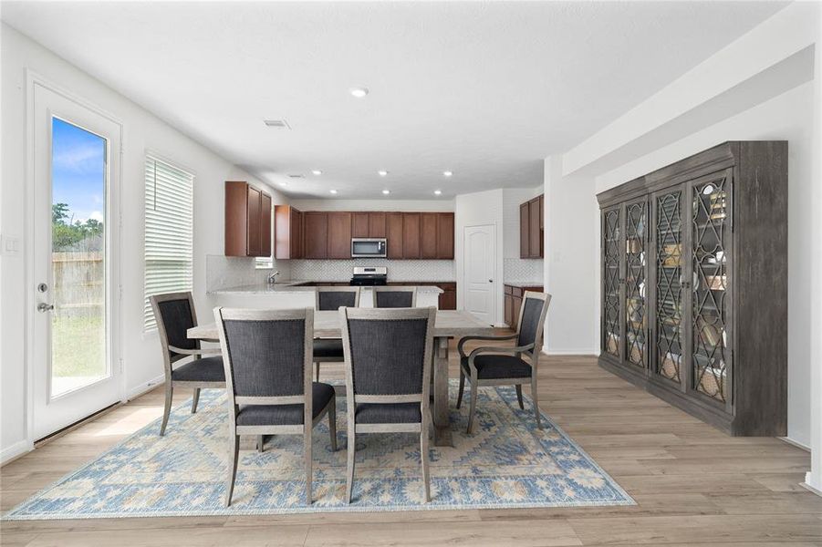 This formal dining area features high ceilings, recessed lighting, large windows with privacy blinds, and tile flooring!