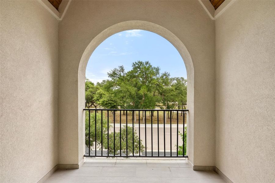 An arched balcony offers verdant tree views and refreshing outdoor space.