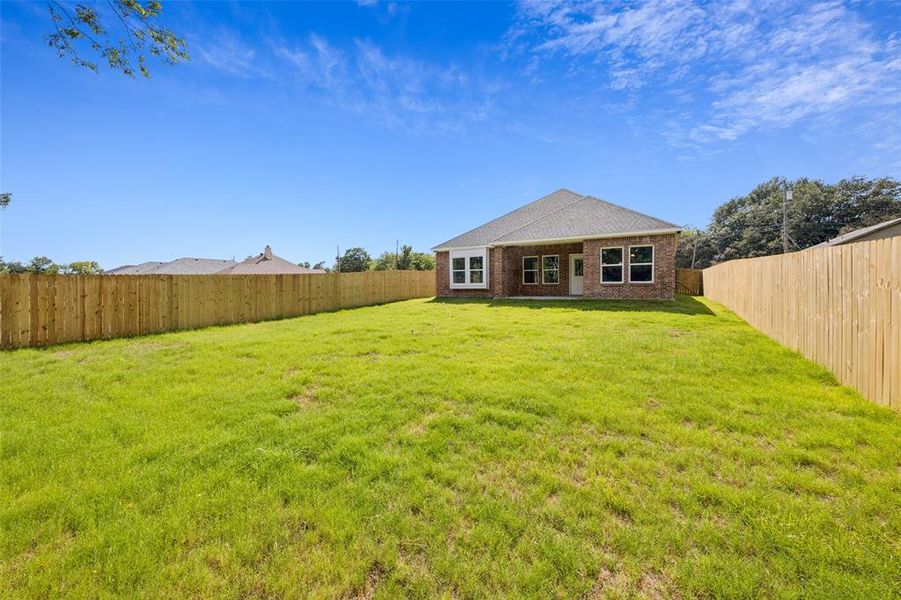 Rear view of property featuring brick siding and a fenced backyard Rear view of property featuring brick siding and a fenced backyard