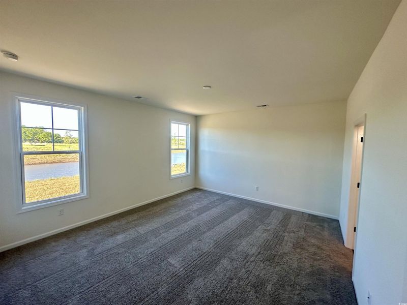 Owners Suite room featuring dark colored carpet and a smoke detector Owners Suite room featuring dark colored carpet and a smoke detector