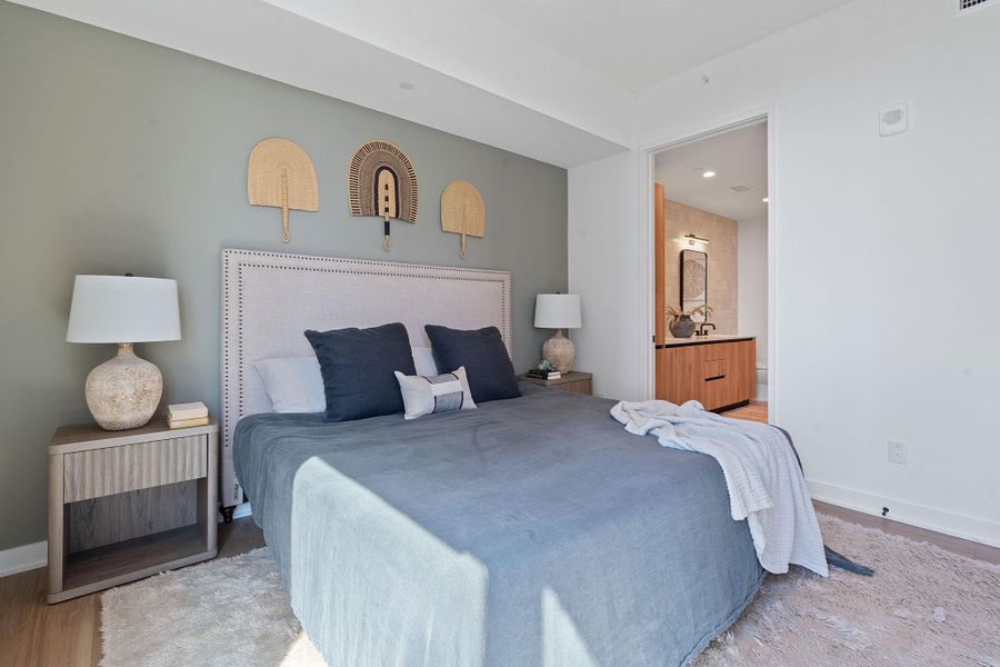 Representative Photo. Primary Bedroom with wood flooring, large window, ceiling fan, and window treatments included