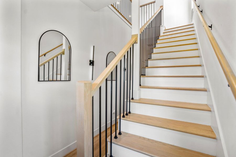A striking staircase with contemporary railing gracefully ascends to the second-floor living area, inviting you upward into a bright, open retreat.