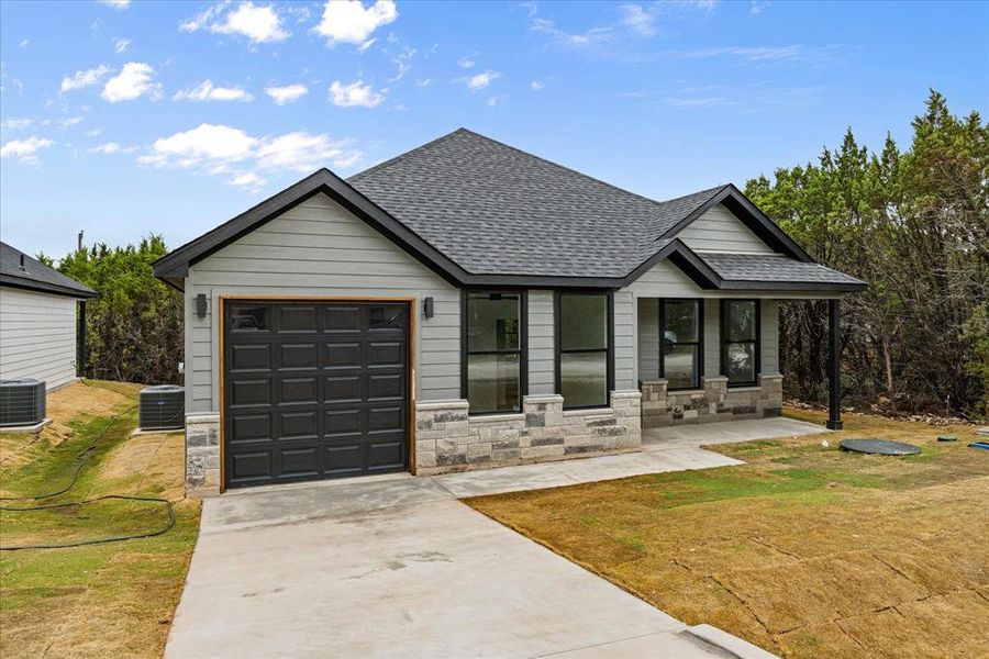 Front exterior of a new home in , Granbury, TX, highlighting curb appeal (Image 1).