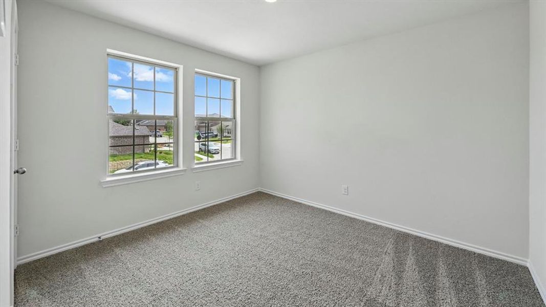 Carpeted spare room featuring baseboards