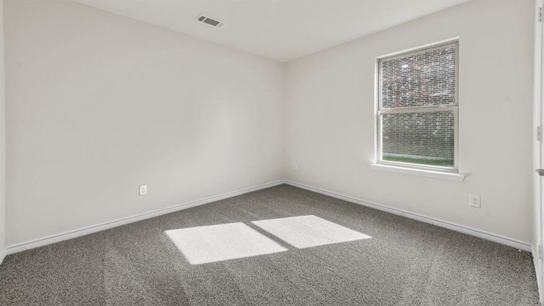 Room featuring light gray walls, gray speckled carpet, and a single window with white trim