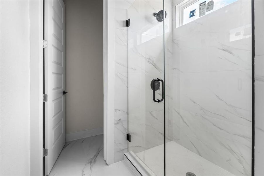 Full bathroom with marble finish floors and a marble finish shower