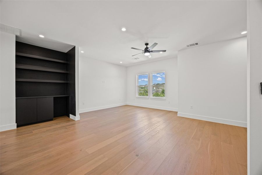 Unfurnished living room featuring recessed lighting, built in features, light wood-style flooring, and a ceiling fan Unfurnished living room featuring recessed lighting, built in features, light wood-style flooring, and a ceiling fan