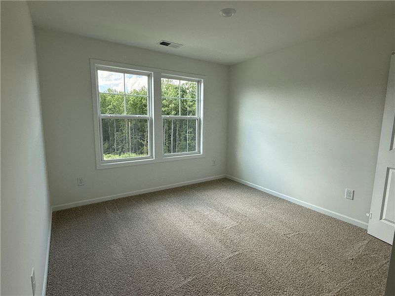 A well-lit bedroom features plush carpeting and la A well-lit bedroom features plush carpeting and la