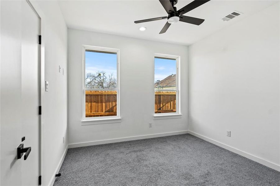 Carpeted spare room with ceiling fan