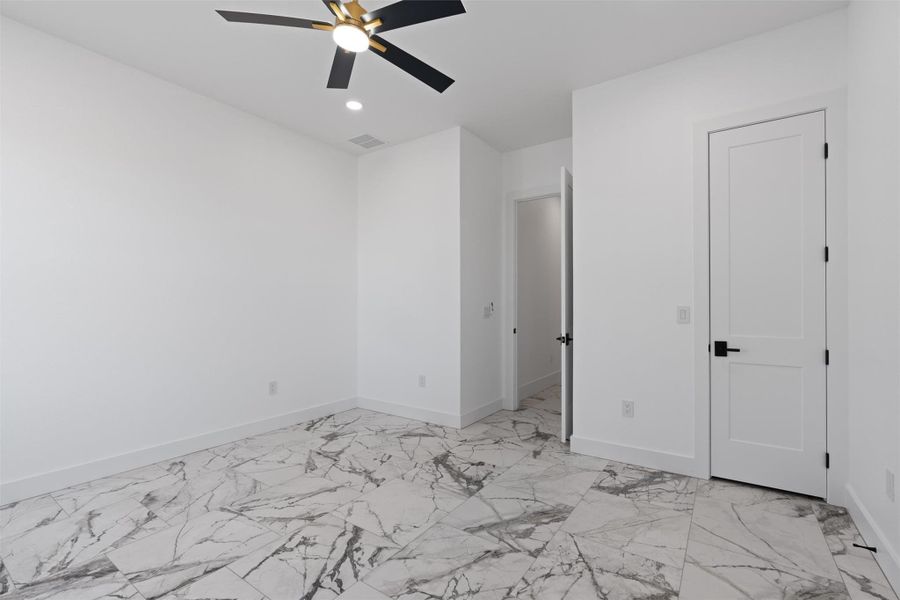 Unfurnished bedroom featuring ceiling fan, light marble finish floors, and recessed lighting