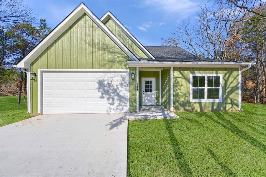 View of front facade featuring a front yard and a garage