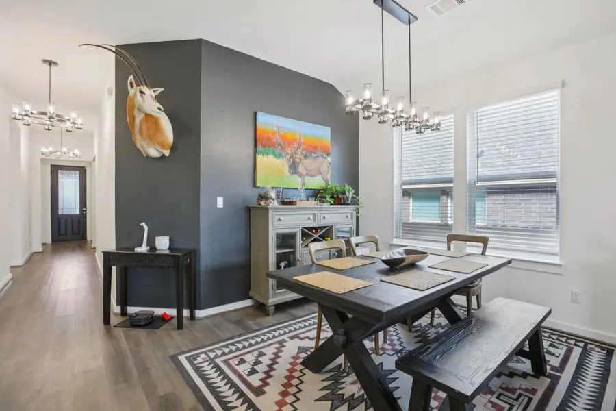 Dining area featuring a chandelier and dark wood-type flooring Dining area featuring a chandelier and dark wood-type flooring