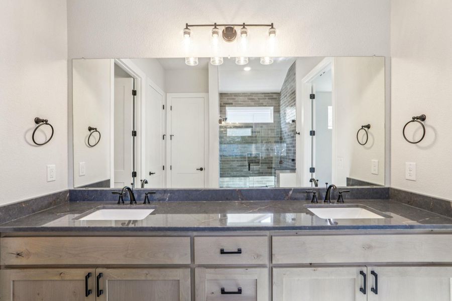 Full bathroom featuring double vanity and a shower stall Full bathroom featuring double vanity and a shower stall