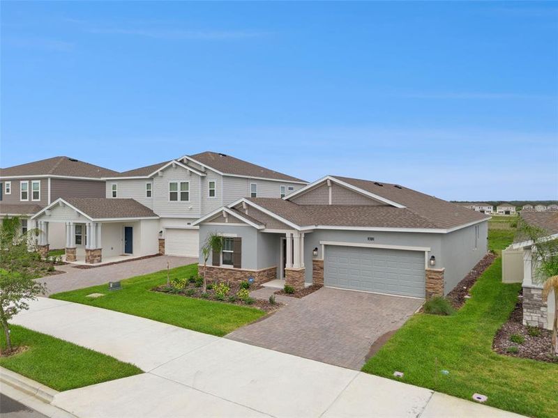 Front exterior of a new home in Wellness Ridge, Clermont, FL, highlighting curb appeal (Image 2). Front exterior of a new home in Wellness Ridge, Clermont, FL, highlighting curb appeal (Image 2).