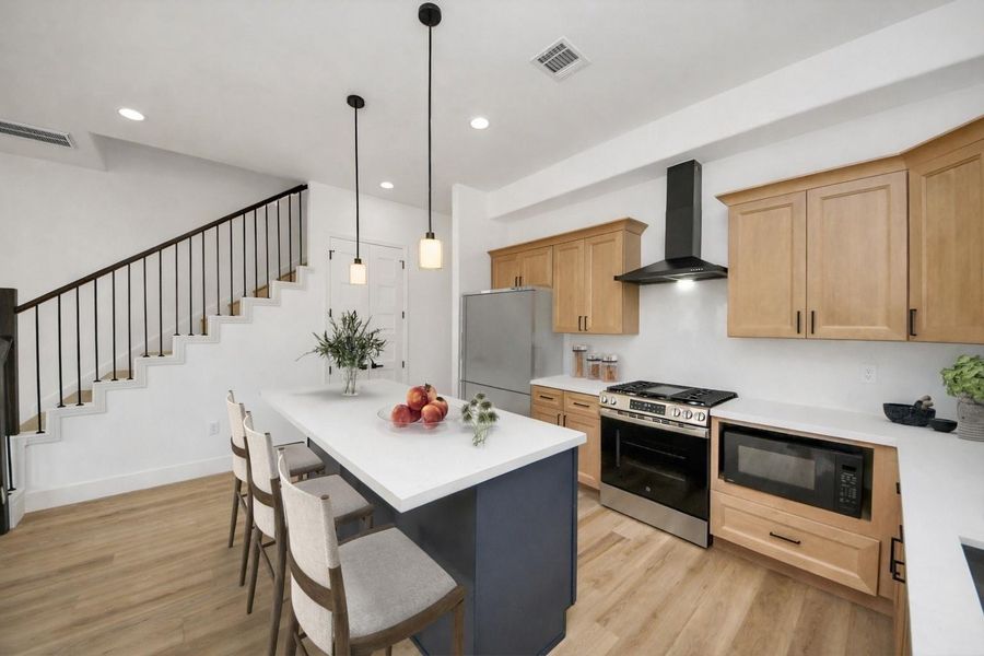 Beautiful kitchen with a large island, ample seating, and warm modern finishes. Open layout and natural light make it perfect for everyday living and entertaining.