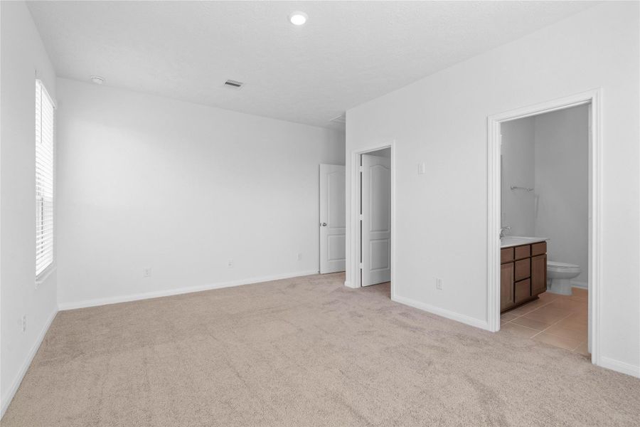 Additional view from the primary bedroom looking to the ensuite bathroom and entrance to walk-in closet. Additional view from the primary bedroom looking to the ensuite bathroom and entrance to walk-in closet.