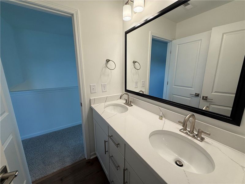 Dual vanities with sleek white countertops and a l Dual vanities with sleek white countertops and a l