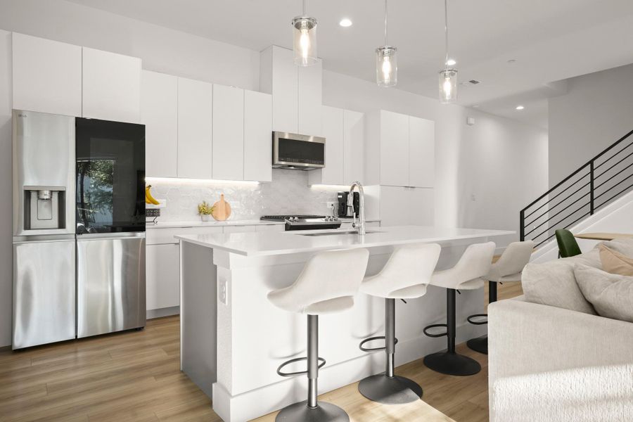 The kitchen comes with custom contamproary cabinetry including built-in pantry storage and offers a large island with bar seating for four. The kitchen comes with custom contamproary cabinetry including built-in pantry storage and offers a large island with bar seating for four.