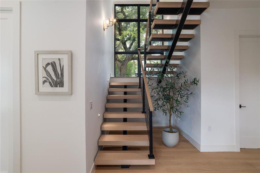 The open box-tread staircase is not only beautiful, it facilitates a thermal siphon effect, drawing warm air upwards and out through the second and third floor windows on cooler days when we can get away with turning off the AC and opening the windows. The picture window at the top of the stairs gives you the impression your walking up into the beautiful live oak canopy....