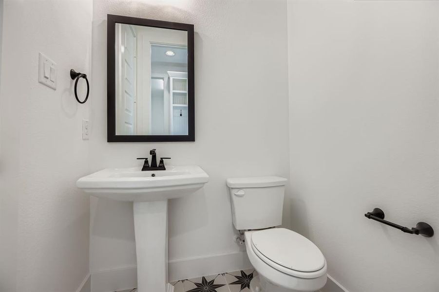 Half bathroom with toilet and baseboards