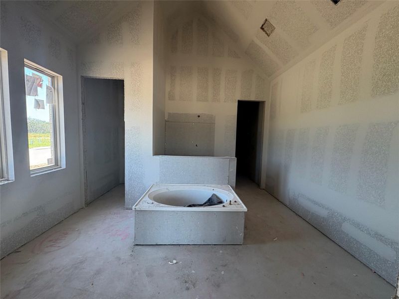 Bathroom featuring a tub and concrete flooring Bathroom featuring a tub and concrete flooring