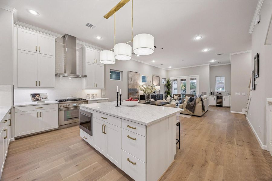 Large island with seating, double-sided storage, and designer pendant lighting.