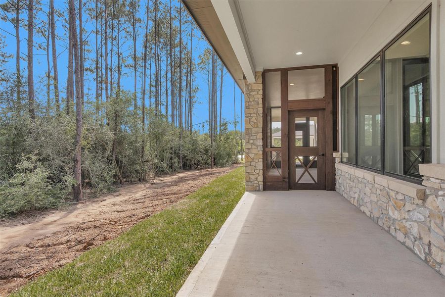 This peaceful covered patio offers a seamless connection to nature with wooded views, stone accents, and direct access to the screened porch and outdoor living spaces. This peaceful covered patio offers a seamless connection to nature with wooded views, stone accents, and direct access to the screened porch and outdoor living spaces.