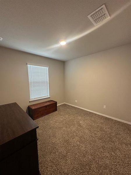 Carpeted spare room featuring baseboards